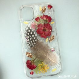 他店には無い「ふわふわの羽」を封じ込めたスマホケース!Studio*Askオリジナル商品です。紅いミニバラとレースフラワーが羽に花を添えています。